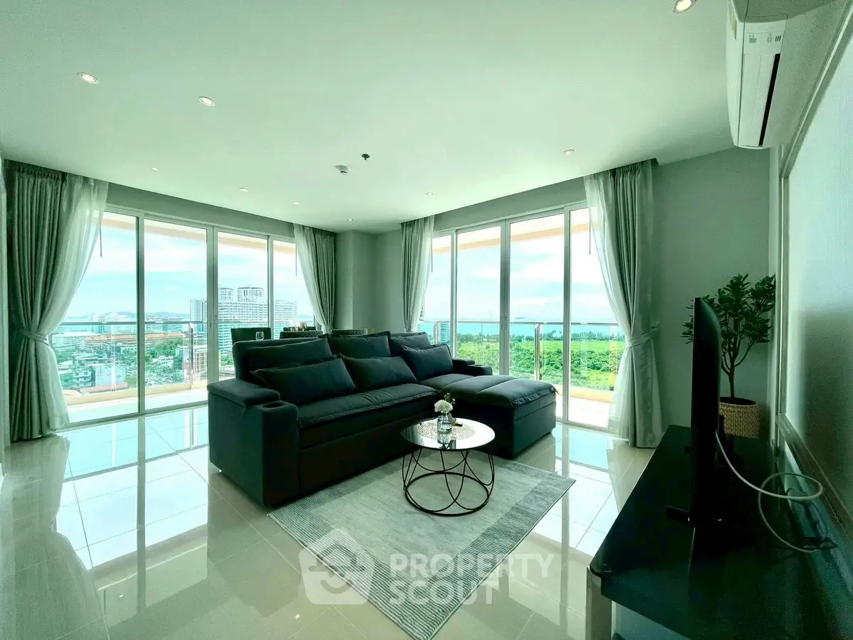 Luxurious living room with panoramic city view and modern furnishings.