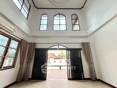 Spacious two-story living room with high ceilings and large windows offering ample natural light.