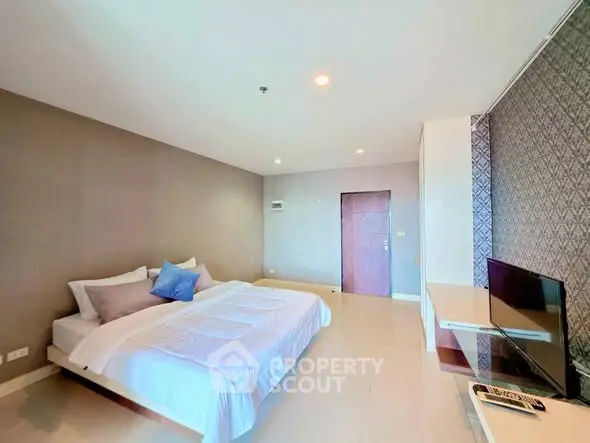 Spacious modern bedroom with stylish decor and natural lighting