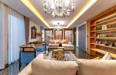 Luxurious living room with elegant chandeliers, plush sofas, and stylish decor in a modern apartment.