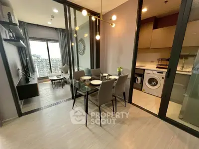 Modern apartment with open layout, featuring dining area, living room, and kitchen with washing machine.