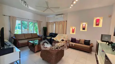 Spacious living room with elegant wicker furniture and modern decor, perfect for relaxation and entertaining.