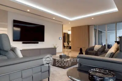 Luxurious modern living room with sleek furniture and large flat-screen TV, perfect for relaxation and entertainment.