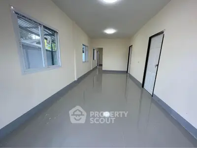 Spacious empty room with glossy tiled floor and multiple doors