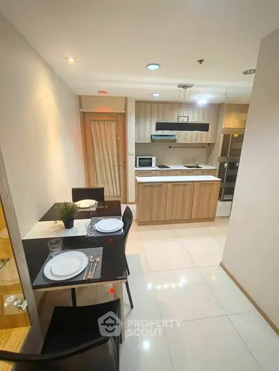 Modern kitchen with dining area, featuring sleek cabinetry and integrated appliances.