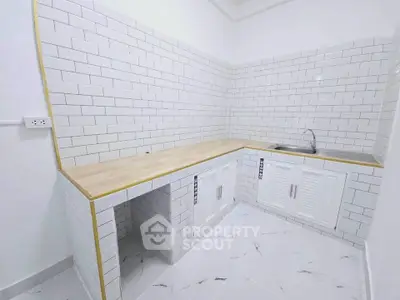 Modern white tiled kitchen with wooden countertop and sleek cabinetry