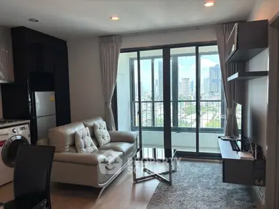 Modern living room with city view, featuring sleek furniture and large windows for natural light.