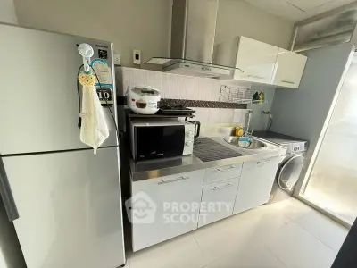 Modern kitchen with stainless steel appliances and sleek cabinetry in a compact layout.