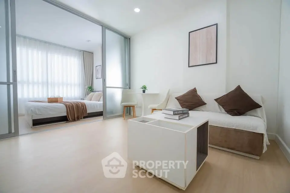 Modern living room with cozy sofa and stylish decor adjacent to a bright bedroom.