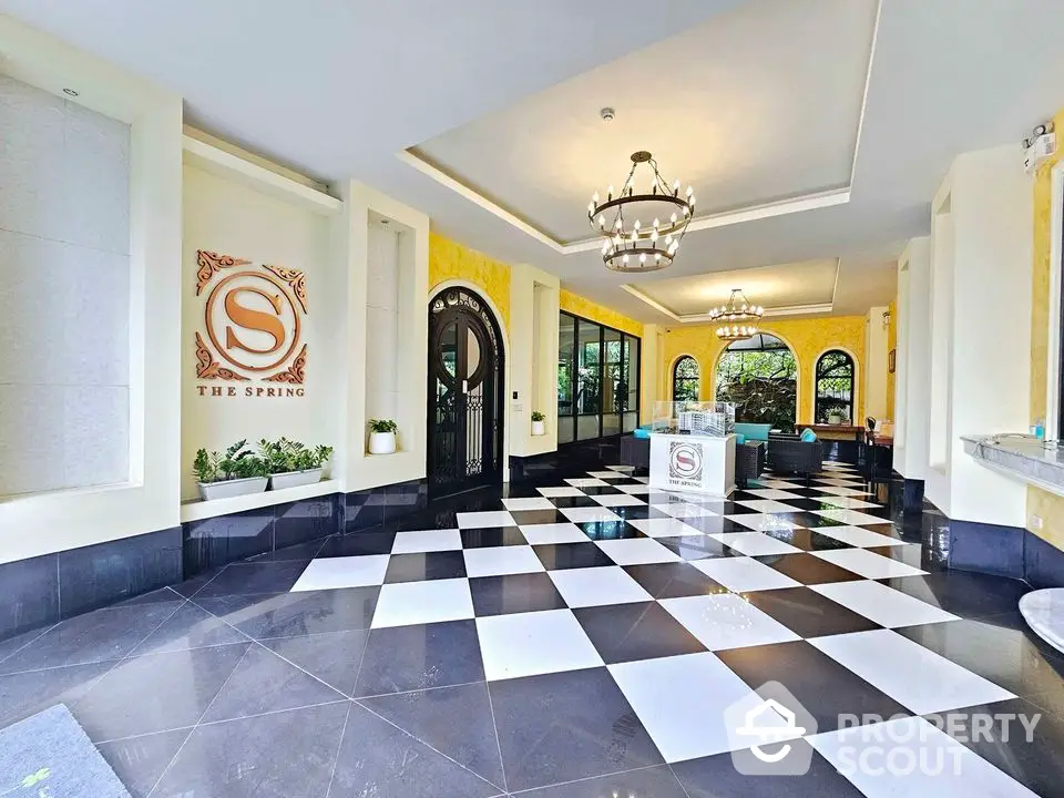 Elegant building entrance with checkered floor and stylish chandeliers at The Spring