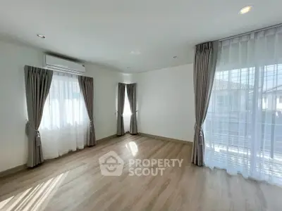 Spacious empty room with large windows and elegant curtains, perfect for customization.