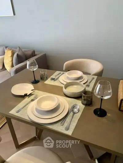 Elegant dining setup in modern living room with stylish tableware and cozy seating.