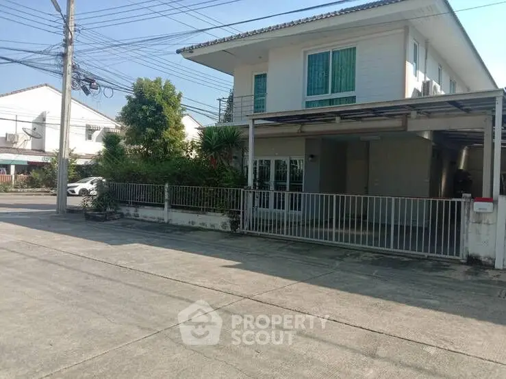 Charming suburban house with gated driveway and lush greenery, perfect for family living.