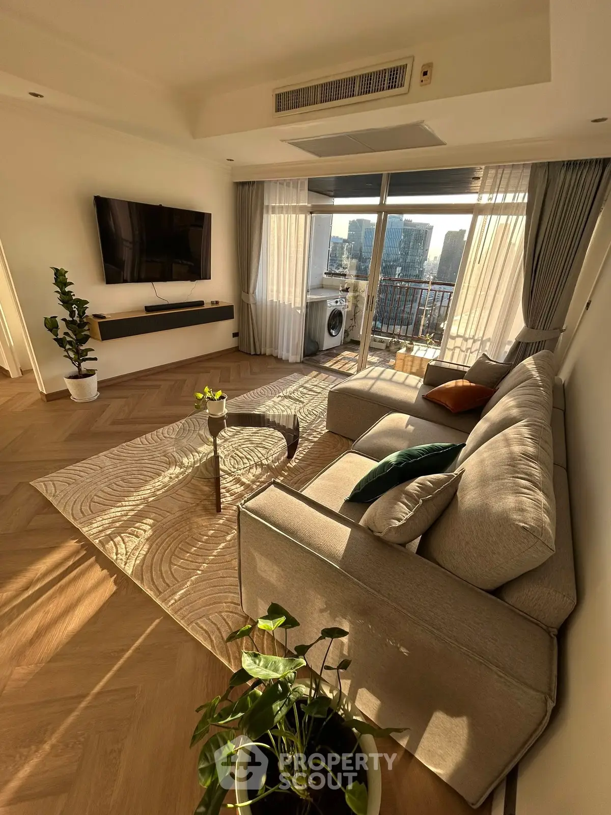 Luxurious living room with modern decor and stunning city view from balcony.