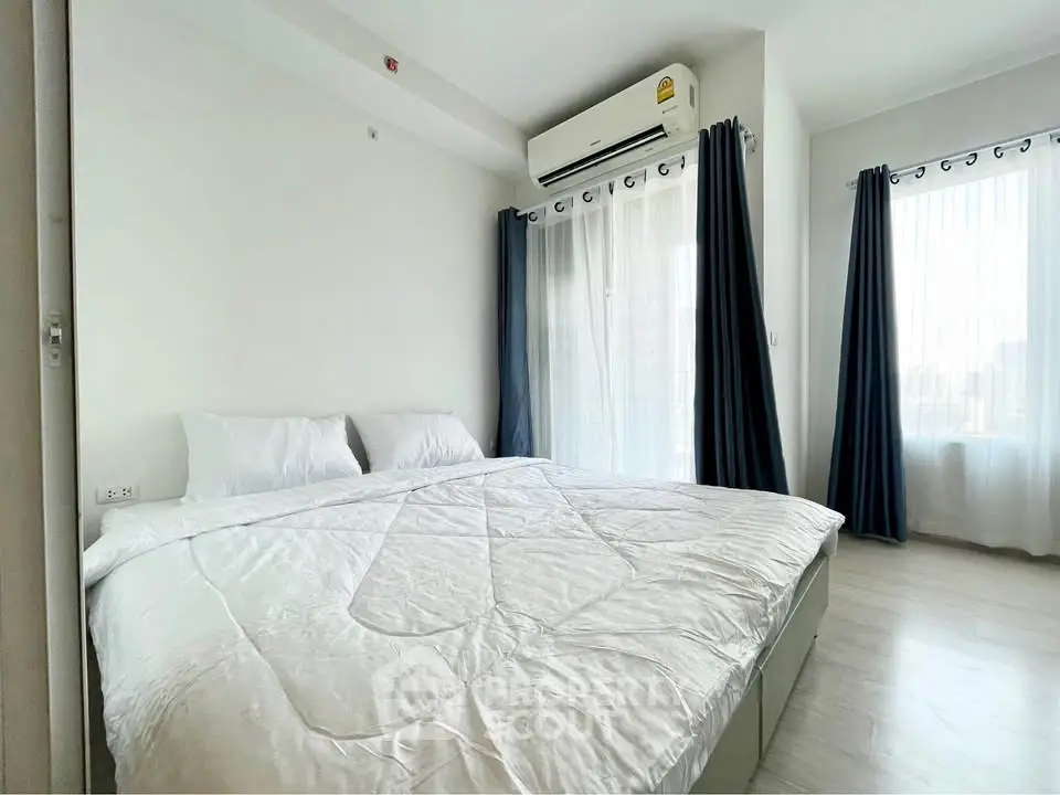 Bright and airy bedroom with large windows and modern air conditioning unit.