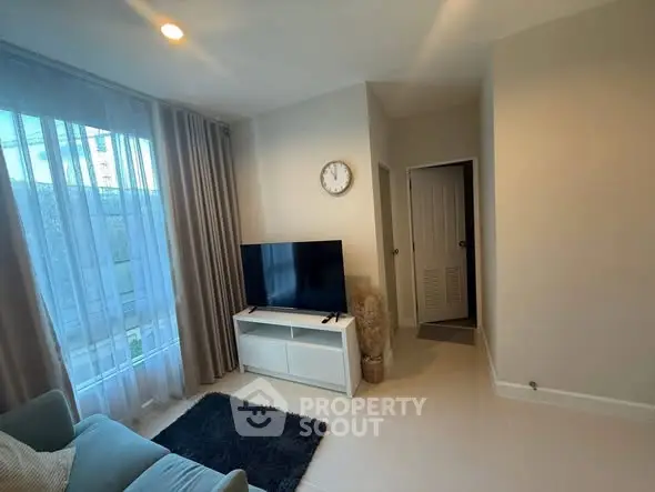 Cozy living room with modern TV setup and natural light