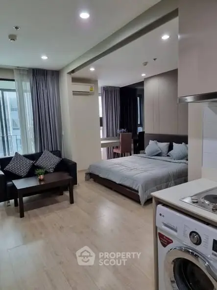Modern studio apartment with open layout, featuring cozy living area and stylish kitchen.
