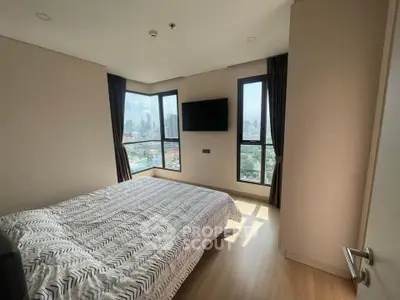 Modern bedroom with city view and wall-mounted TV