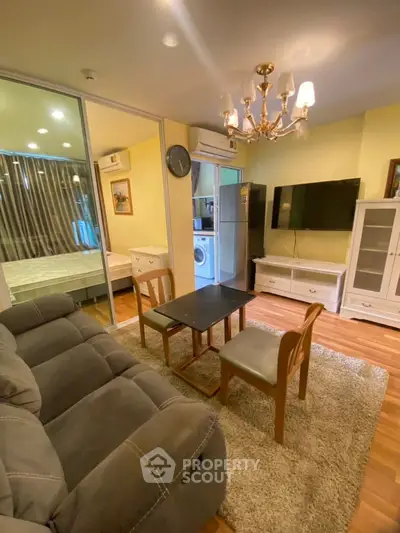 Cozy living room with elegant chandelier and modern furnishings in a stylish apartment.