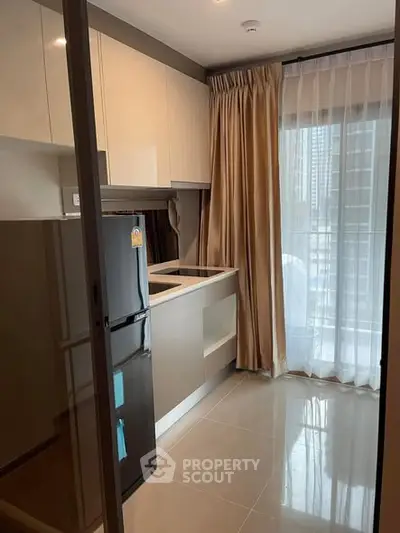 Modern kitchen with sleek cabinets and large window for natural light.