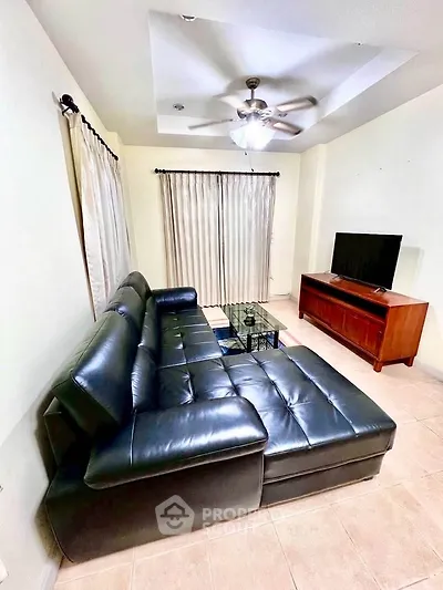 Spacious living room with leather sectional sofa and modern entertainment center.