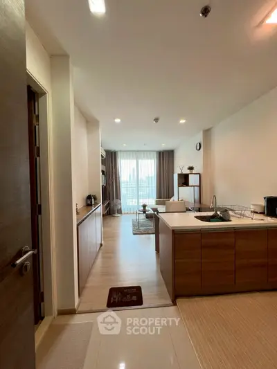 Spacious open-layout kitchen and living room with modern decor and natural light.