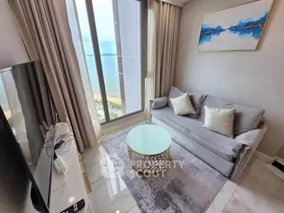 Modern living room with stunning sea view, elegant decor, and floor-to-ceiling windows.