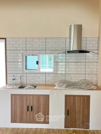 Modern kitchen with sleek cabinetry and stainless steel range hood.