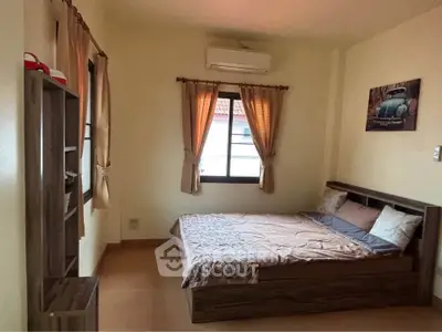 Cozy bedroom with wooden furniture and natural light from window.