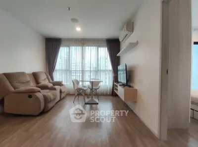 Spacious living room with modern furniture and large window for natural light.