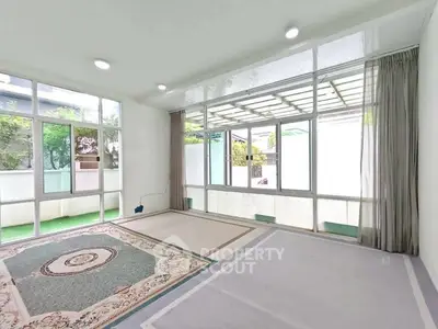 Spacious sunlit room with large windows and elegant carpet, perfect for versatile living space.