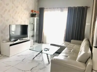 Modern living room with sleek furniture and large TV, perfect for relaxation.