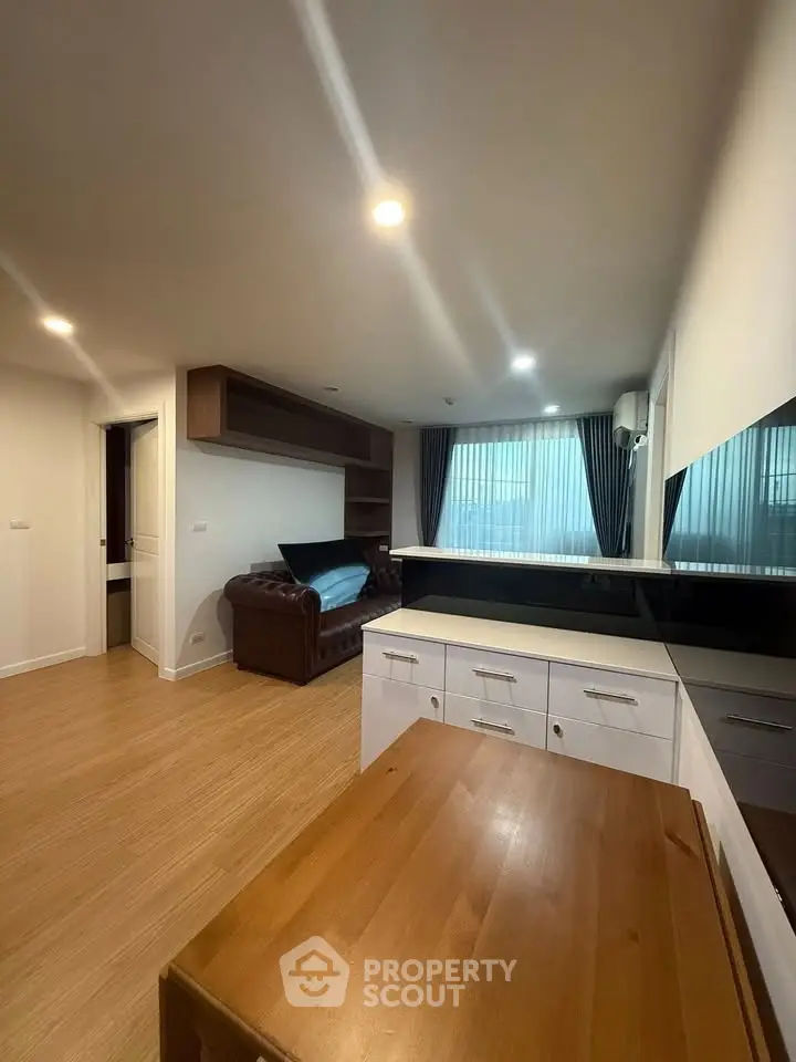 Modern living room with wooden flooring and stylish furniture in a cozy apartment setting.