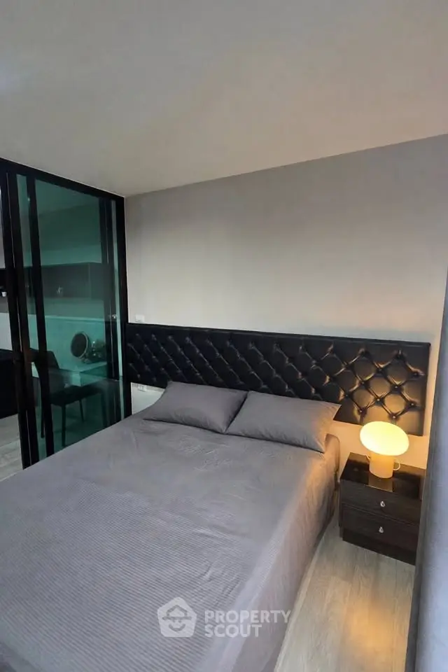 Modern bedroom with stylish headboard and ambient lighting in a contemporary apartment.