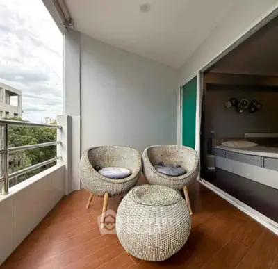 Charming balcony with cozy seating and bedroom view, perfect for relaxation.
