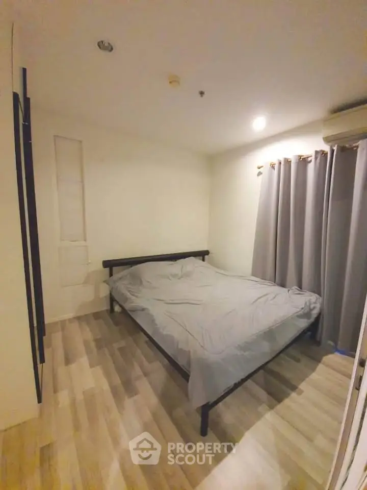 Cozy bedroom with modern decor and natural light, featuring a comfortable bed and stylish flooring.