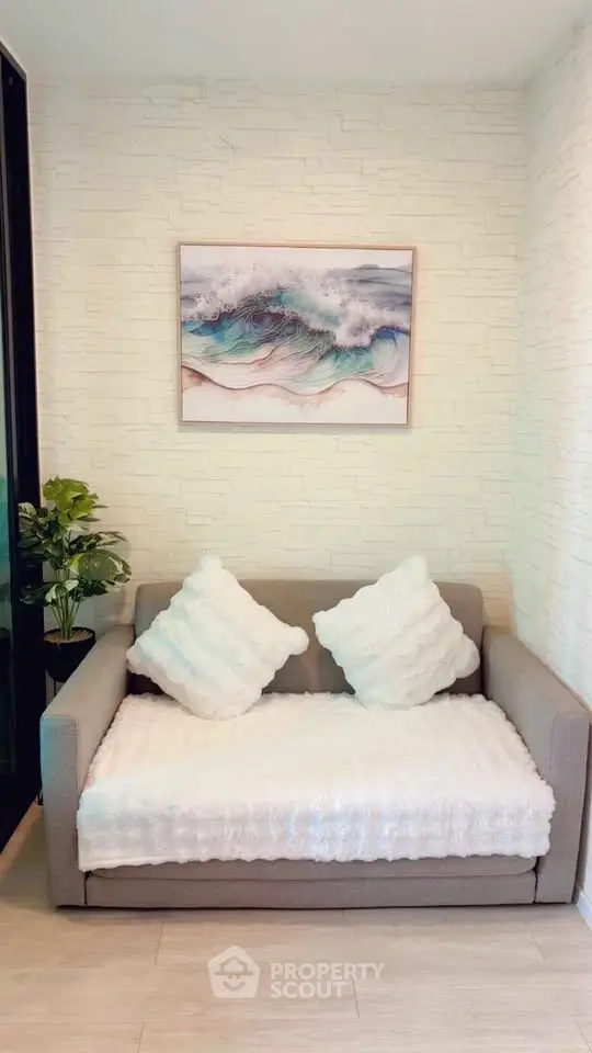 Cozy living room with stylish sofa and wave artwork