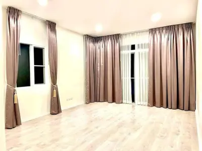 Spacious empty room with elegant curtains and wooden flooring