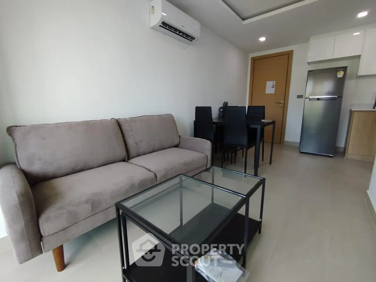 Modern living room with sleek furniture and open kitchen layout in a stylish apartment.