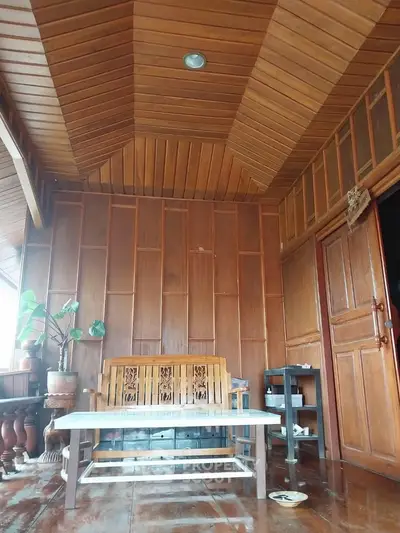 Charming wooden interior with high ceiling and cozy seating area, perfect for relaxation.