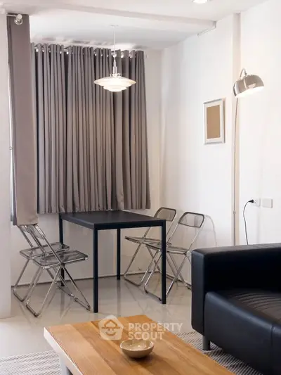 Modern living room with sleek furniture and elegant lighting, featuring a cozy dining area and stylish decor.