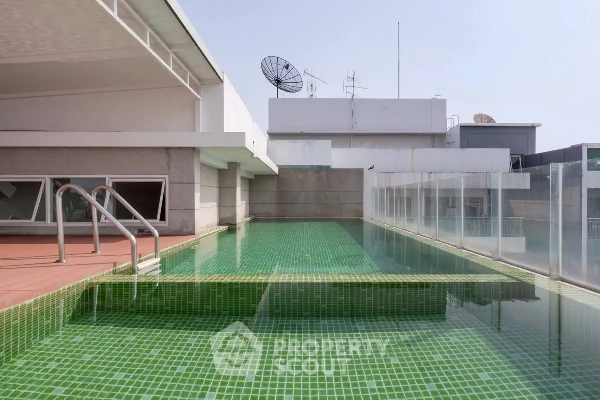 Modern rooftop pool with glass railing and city views