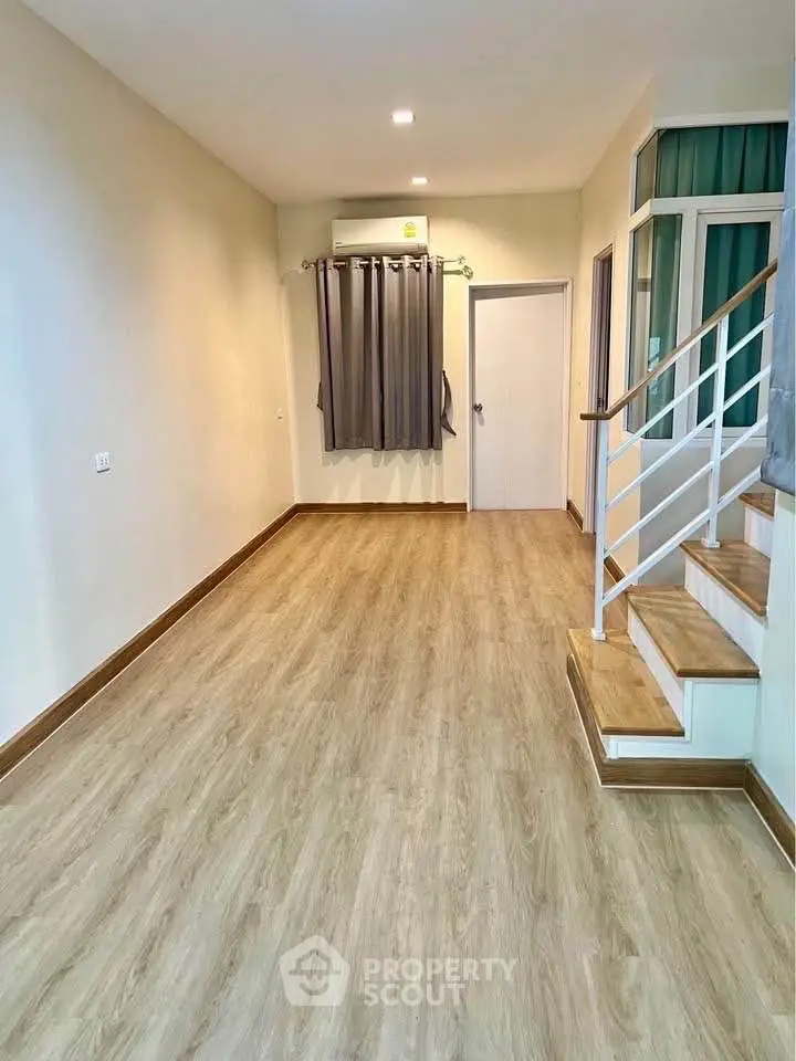 Spacious modern living room with wooden flooring and staircase