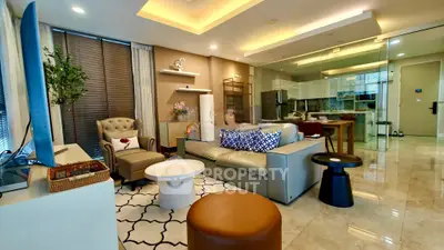 Luxurious modern living room with open kitchen, elegant decor, and ample natural light.