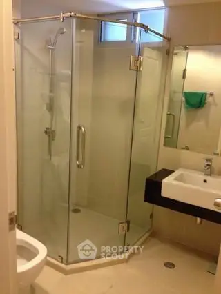 Modern bathroom with glass shower enclosure and sleek fixtures