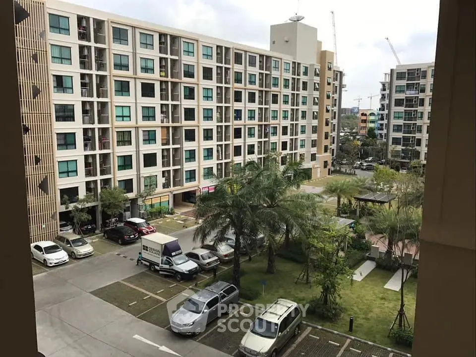 Modern apartment complex with lush greenery and ample parking space