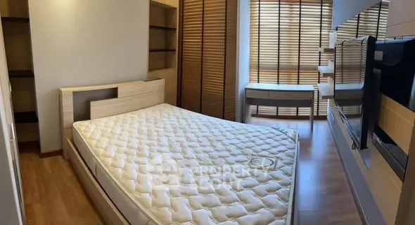 Modern bedroom with wooden flooring and stylish blinds, featuring a comfortable bed and ample storage space.