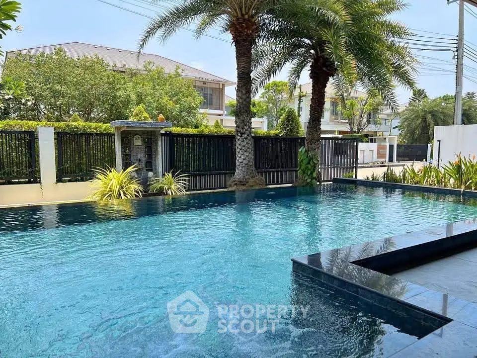 Luxurious outdoor pool with palm trees in a serene residential setting