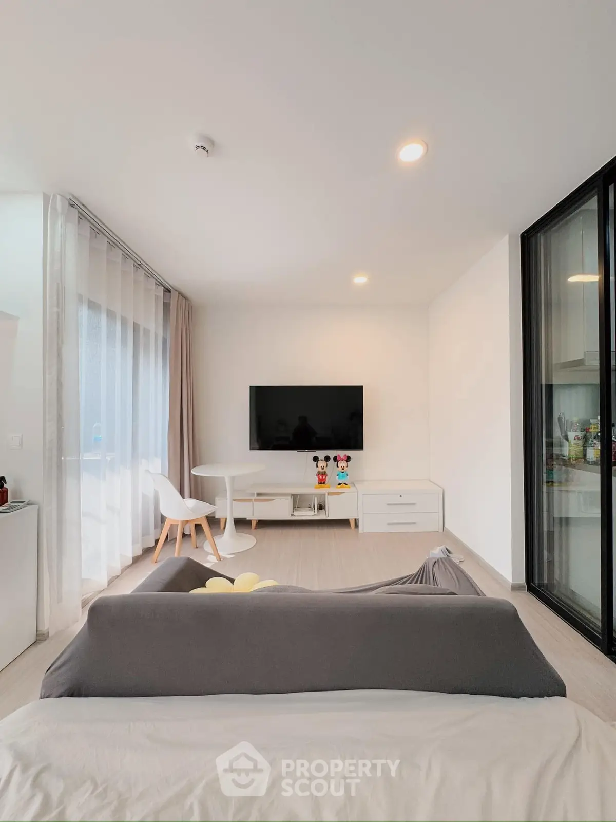Modern living room with sleek design, featuring a wall-mounted TV and cozy seating area.