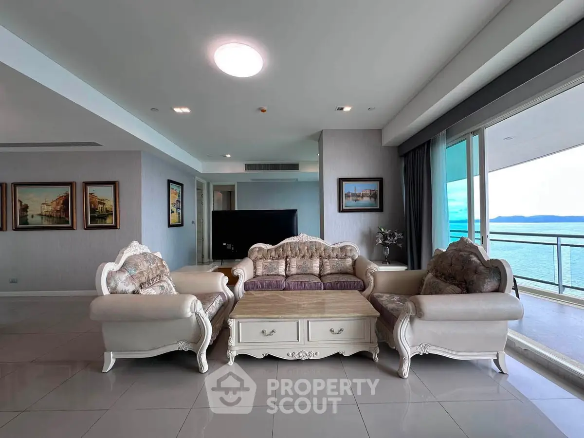 Luxurious living room with elegant furniture and stunning ocean view balcony.